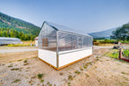 Harvest greenhouse with polycarbonate roof and white skirt, Okanagan mountains behind