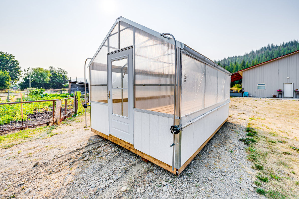 Harvest greenhouse from the front corner showing the storm door and roll-up side