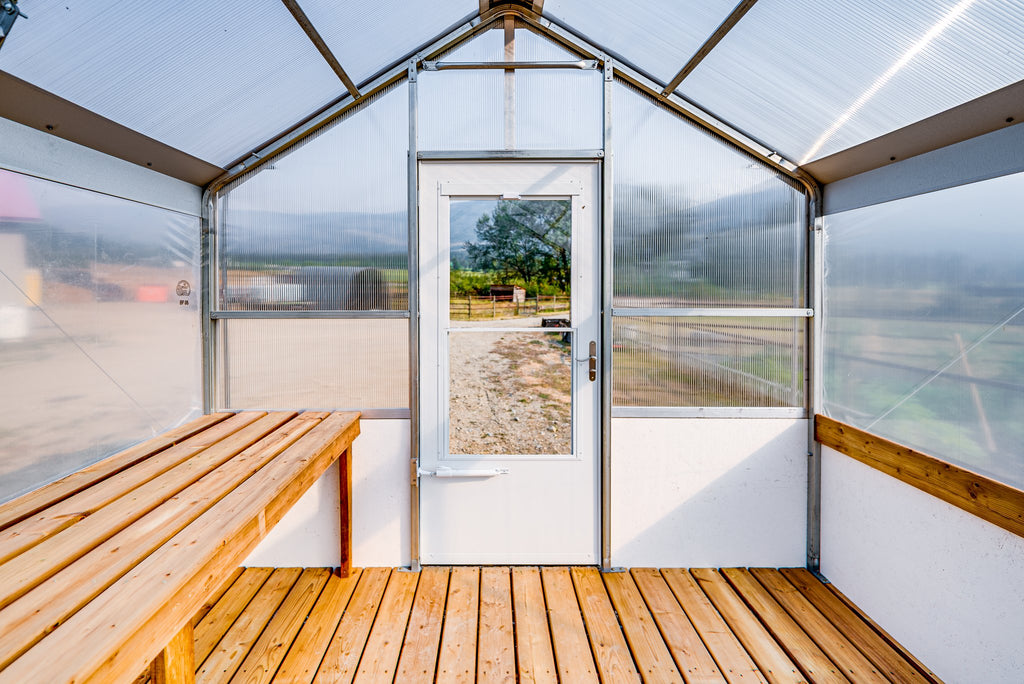 Inside the Harvest greenhouse looking toward the door, full-length heavy-duty work bench